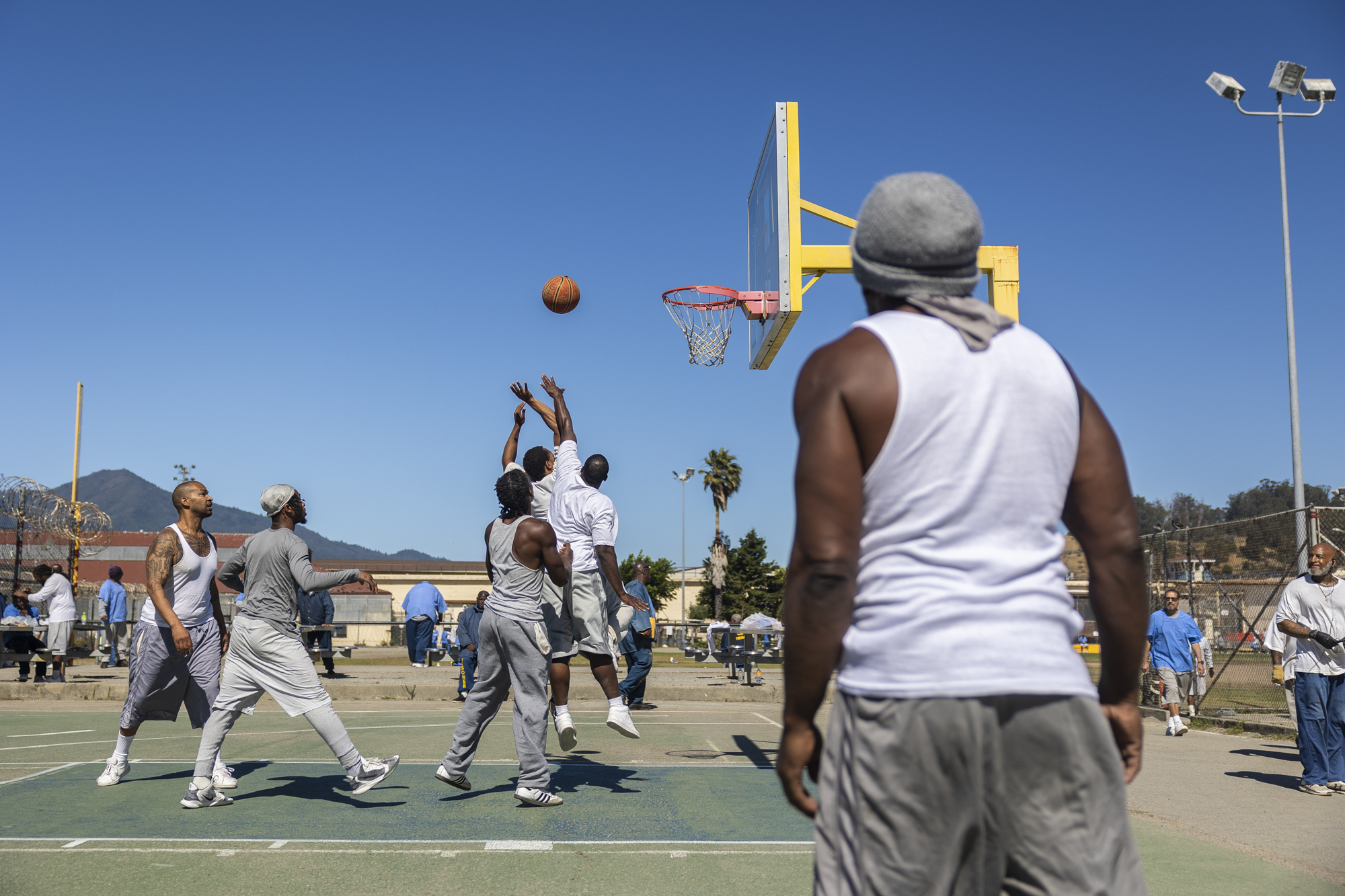 People jump for a ball on a basketball court.