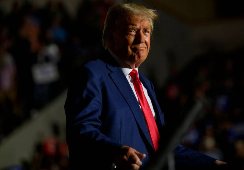 Former President Donald Trump, wearing his characteristic red tie, during a political rally.