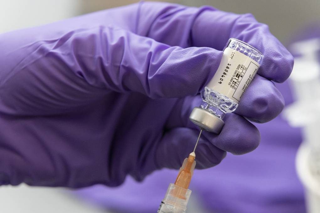 A gloved hand loads a syringe with the Covid-19 Johnson &amp; Johnson vaccine.