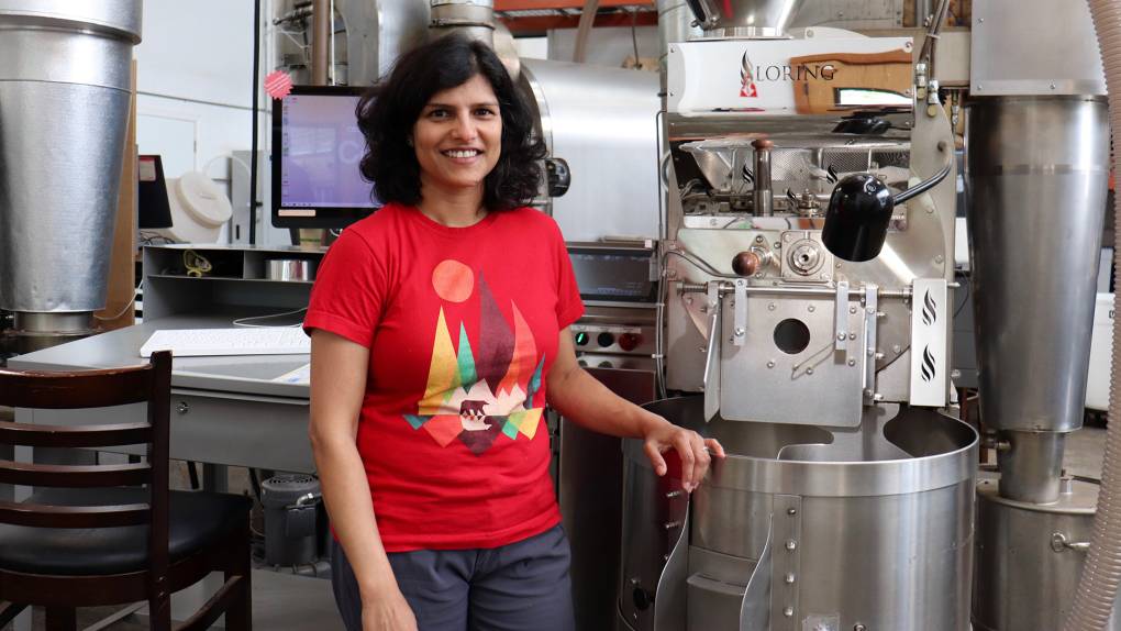 the owner of Kaveri Coffee works stands in front of the roasting machine she uses in Berkeley