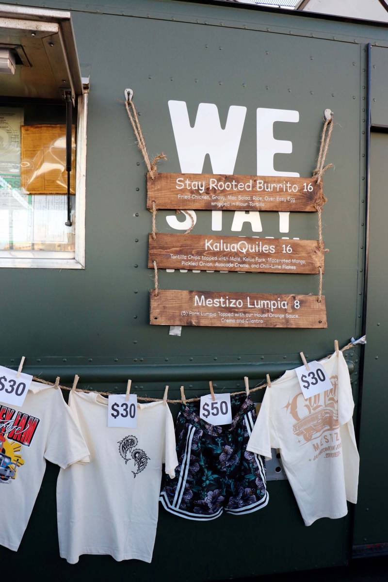 a food truck displays their food menu, along with custom t-shirts and basketball shorts