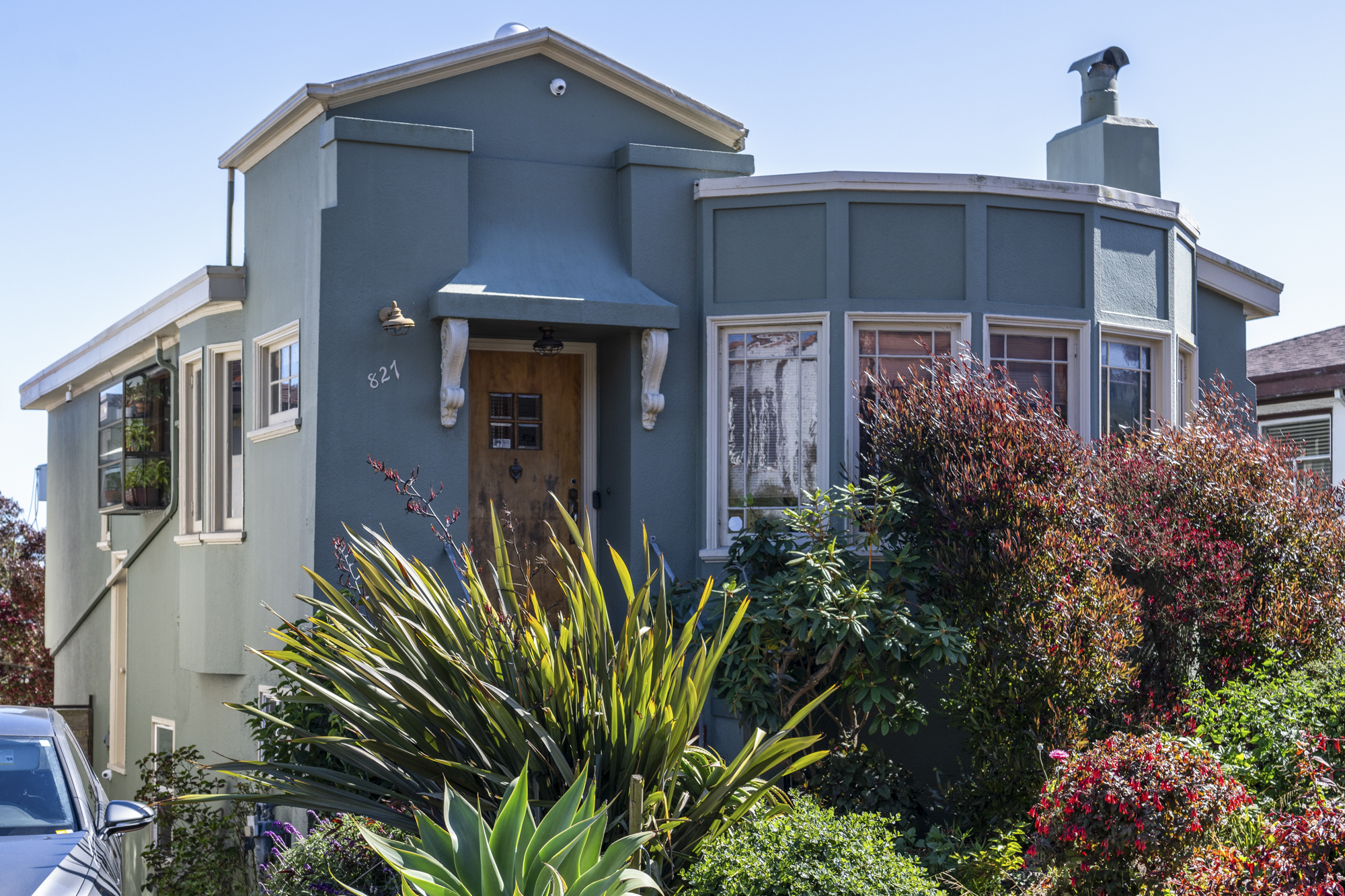 A house in a residential neighborhoods with a verdant front garden.